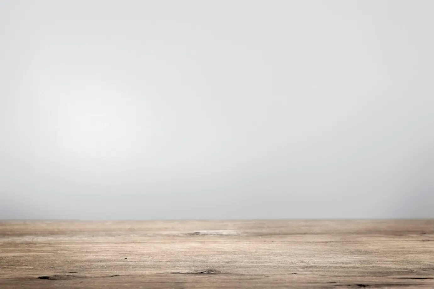 Produkt-Hintergrund mit einer schlichten grauen Wand und einem Holzboden.